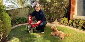 pest technician in gear with dog on lawn.